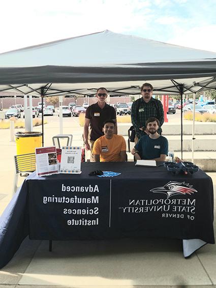 Advanced Manufacturing Club members sitting at the a booth on Manufacturing Day 2021